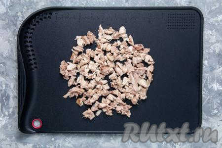 Выньте сваренное куриное мясо из кастрюли и остудите. Отделите филе от костей, удалите кожу и нарежьте на кусочки. Положите нарезанную курицу назад в бульон.