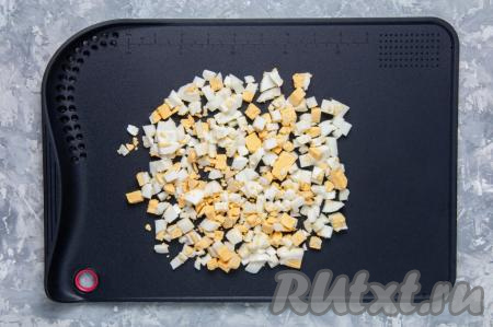 В отдельной ёмкости сварите яйца вкрутую (варим 9-10 минут с момента закипания воды). Остудите их, почистите, нарежьте на небольшие кубики.