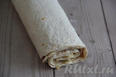 Завернуть лаваш с начинкой в рулет, начиная с широкого края. Поместить рулет в холодильник на 1 час.