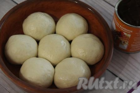 Завернуть края лепёшки, запечатав начинку внутри, сформировав круглую булочку. Аналогично сформировать все булочки с варёной сгущёнкой. Выложить булочки в форму для выпечки, предварительно смазанную растительным маслом. Прикрыв форму полотенцем, оставить булочки на 30 минут для подхода.