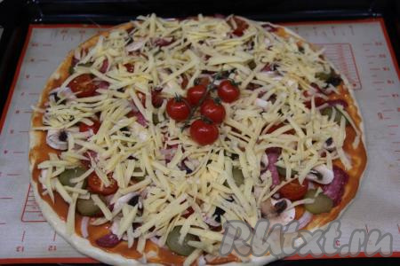 Посыпать пиццу натёртым сыром.