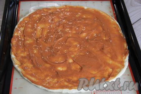 На противень выложить силиконовый коврик (или пергамент). Руки смазать маслом и выложить тесто на противень. Растянуть тесто руками в круг диаметром 28 сантиметров. Смешать отдельно кетчуп с майонезом. Смазать творожную основу пиццы смесью майонеза и кетчупа.