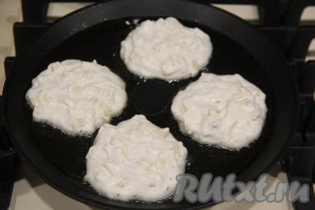 В сковороду влить растительное масло, хорошо его разогреть. Выкладывать на сковороду по 1 столовой ложке творожно-яблочного теста, формируя круглые оладьи.