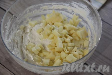 Нарезать на мелкие кубики яблоко, очищенное от кожуры и семечек. Добавить кубики яблока в творожное тесто.
