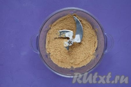 Измельчите печенье в крошку (можно измельчить печенье в блендере, а можно выложить его в целлофановый пакет и прокатать скалкой поверх пакета, превращая печенье в крошку).