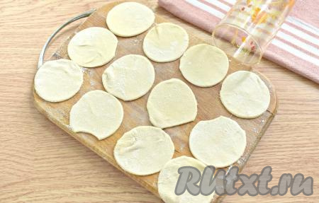 Тесто делим на 3 куска. Каждый кусок теста на присыпанной мукой поверхности раскатываем в тонкий пласт толщиной, примерно, 2 миллиметра. С помощью стакана вырезаем круглые заготовки для пельменей (я вырезала кружочки диаметром 6 сантиметров).