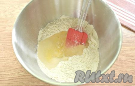 В центр углубления в муке разбиваем сырое яйцо. Вливаем одну столовую ложку растительного масла и охлаждённую кипячёную воду.