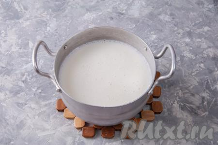 После того как рис проварится минут 8-10, добавьте в кастрюлю кипящее молоко, перемешайте, дайте закипеть, а затем варите на небольшом огне 8 минут (до мягкости рисинок). Кастрюлю с готовой рисовой кашей снимите с огня, накройте крышкой и оставьте остывать до 60-70 градусов (на это потребуется минут 40).