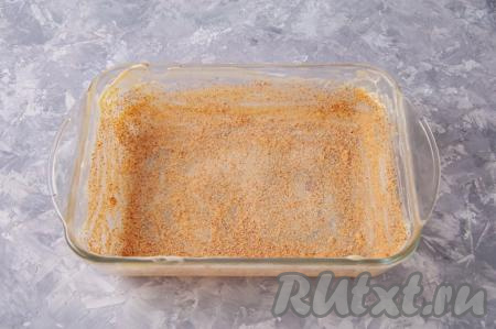 Возьмите жаропрочную форму (у меня форма размером 17 сантиметров на 24 сантиметра). Для того чтобы запеканка не пристала к форме, смажьте форму обильно сливочным маслом, затем присыпьте панировочными сухарями.