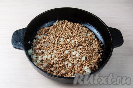 Гречку переберите, удаляя порченые зёрна, затем хорошо промойте, слейте с крупы лишнюю жидкость. К луку, обжаренному до прозрачности, добавьте подготовленную гречку, перемешайте и обжаривайте 2-3 минуты, периодически помешивая.