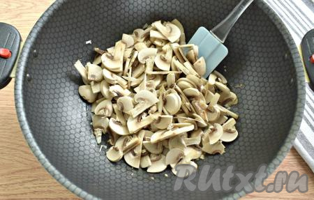 Если вы готовите блюдо с лесными грибами, тогда промойте их, выложите в кастрюлю с водой и отварите с момента закипания в течение минут 25-30 на небольшом огне, затем слейте лишнюю воду. Свежие шампиньоны просто промойте водой, убирая загрязнения на грибочках. 150 грамм шампиньонов (или отваренных лесных грибов) нарезаем на небольшие кусочки и выкладываем к обжаренному луку, перемешиваем и готовим минут 5, периодически помешивая.