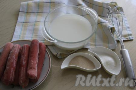 Подготовить продукты для приготовления сосисок в дрожжевом тесте на сковороде. Соединить молоко и воду, подогреть до 40 градусов. В тёплую смесь молока и воды всыпать дрожжи и сахар, перемешать и оставить опару минут на 15 в тепле.