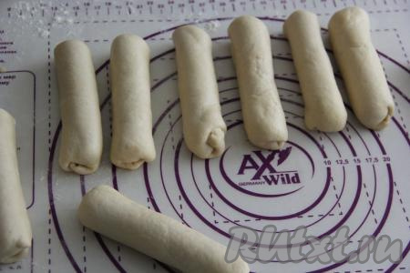 Подвернуть вначале тесто с двух узких сторон овала на концы сосисок, а затем, начиная с широкой стороны овала, завернуть сосиску в тесто. Сформировать все 15 заготовок сосисок в тесте.