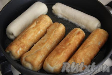 Жарить сосиски в тесте на среднем огне, переворачивая, до золотистого цвета со всех сторон.