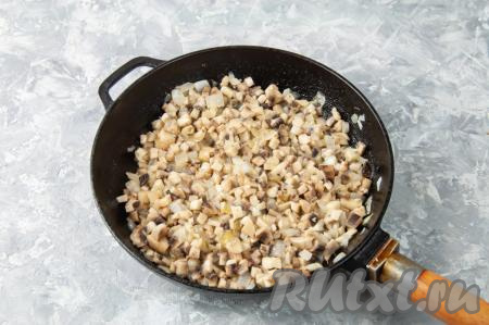К обжаренным луку с чесноком добавьте подготовленные шампиньоны (или лесные грибы) и обжаривайте 6-8 минут, периодически помешивая.