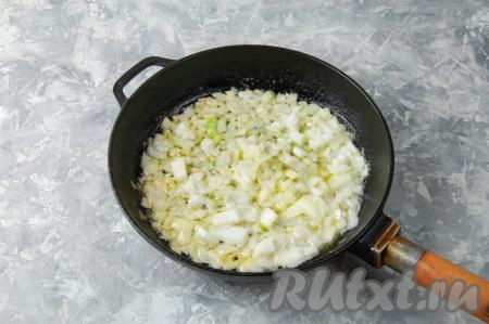 На разогретую сковороду выложите сливочное масло и лук с чесноком, помешивая, обжарьте овощи на среднем огне в течение 3-4 минут (до прозрачности лука).