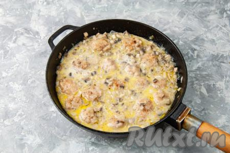 Влейте в сковороду к тефтелям и грибам тёплое молоко, посолите и поперчите, перемешайте, убавьте огонь до ниже среднего. Прикройте сковороду крышкой и тушите до готовности (примерно, 15 минут). В процессе тушения один-два раза переверните тефтельки на другую сторону, чтобы они пропитались грибным соусом со всех сторон.