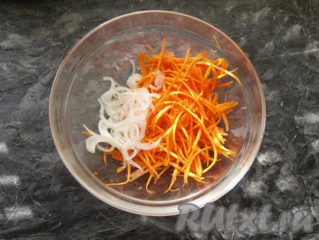 Пока огурцы просаливаются, морковку натереть на корейской тёрке в отдельную миску, добавить нарезанный тоненькими полукружочками (или перьями) репчатый лук.