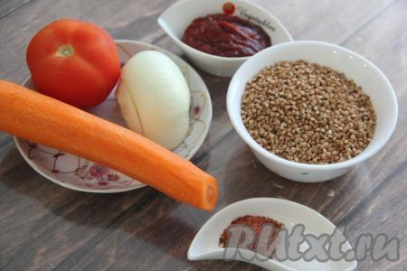 Подготовить продукты для приготовления гречки с помидорами на сковороде. Лук и морковь почистить. Помидор вымыть. Гречку перебрать и промыть, лишнюю воду слить.