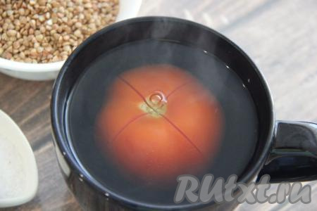 На поверхности помидора сделать крестообразный разрез и поместить его в глубокую миску. Залить помидор крутым кипятком и оставить на 5 минут.