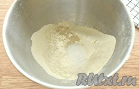 Прежде всего замесим тесто, для этого просеиваем в объёмную миску муку, добавляем к ней сахар, соль и сухие дрожжи, сразу перемешиваем.