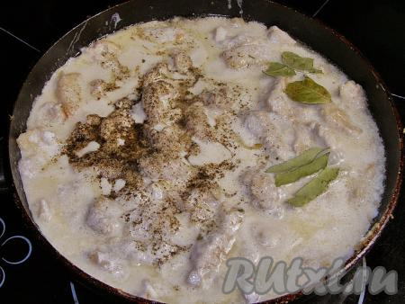 Добавляем лавровый лист, перчим (можно добавить и горошины чёрного перца), солим и снова перемешиваем, доводим сметанный соус до кипения, уменьшаем огонь до минимального и готовим бефстроганов из свинины на сковороде под крышкой минут 25-30 (до мягкости мяса), иногда перемешивая.