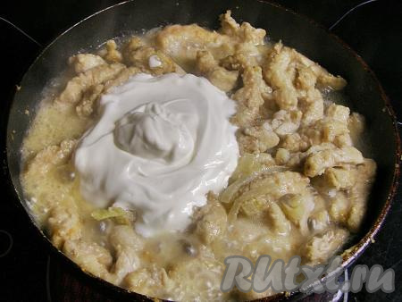 Затем в сковороду к свинине с луком добавляем сметану и горячую кипячёную воду, перемешиваем.