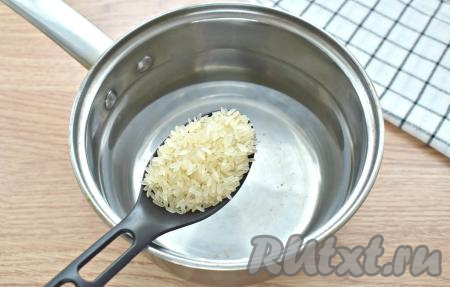 В первую очередь отварим до полуготовности рис, для этого наливаем в кастрюлю воду, ставим на сильный огонь, а после закипания всыпаем предварительно промытый рис, перемешиваем, снова даём закипеть, а после этого варим минут 10 на небольшом огне. Варёный рис откидываем на сито, ополаскиваем холодной водой и оставляем на несколько минут, чтобы стекла лишняя вода.