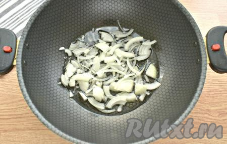 Очищаем морковку и лук. Плодоножку с семенами убираем из болгарских перцев. В глубокую кастрюлю (сковороду, сотейник или казан) вливаем растительное масло, на огонь пока не ставим. Репчатый лук нарезаем полукольцами (или четверть кольцами), выкладываем первым слоем.