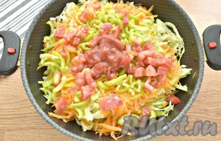 Овощи посыпаем солью, сахаром, чёрным молотым перцем. Добавляем томатную пасту и вливаем 100 миллилитров тёплой кипячёной воды. Перемешивать ингредиенты не нужно.