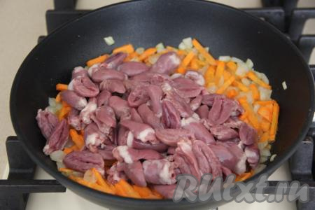 К обжаренным овощам выложить подготовленные куриные сердечки.