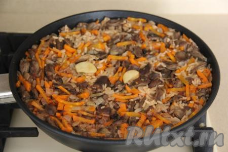Готовый плов снять с огня и, убрав чеснок, перемешать.