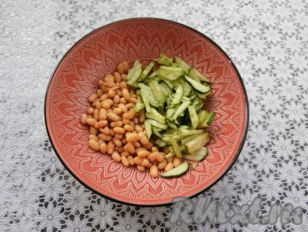 Сварить вкрутую яйцо (на это потребуется после начала кипения воды минут 9-10). Фасоль промыть, обсушить, переложить в миску, добавить нарезанный соломкой свежий огурец.