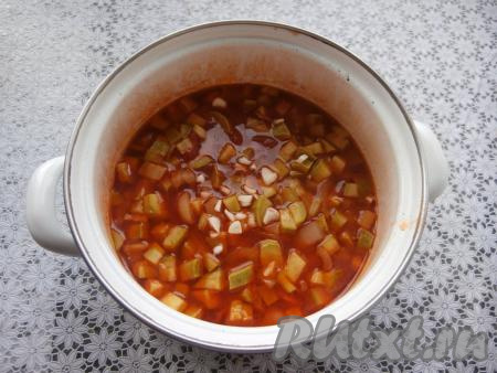 Довести до кипения, а затем варить под крышкой 15 минут на слабом огне. Далее добавить измельчённый чеснок, перемешать и варить ещё 15 минут.