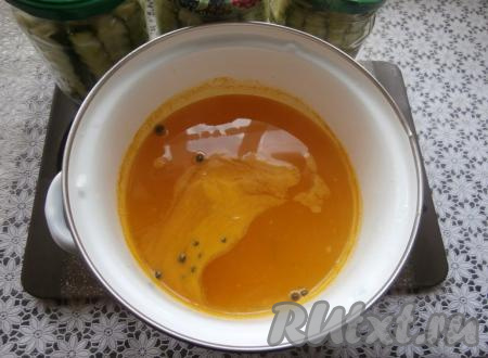 После того как вода в кастрюле закипит, на небольшом огне проварить 2-3 минуты (кристаллы соли и сахара за это время полностью растворятся), затем всыпать куркуму, влить столовый уксус, перемешать, довести маринад до кипения и убрать с огня.