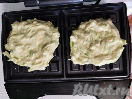 ​​​​​​Смазать панели электровафельницы растительным маслом и разогреть.​​​​​​ Выкладывать на каждую панель электровафельницы 1,5 столовых ложки кабачкового теста, закрыть крышку и выпекать вафли до румяности (примерно 5 минут).