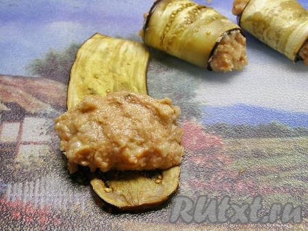 На остывшую пластинку баклажана кладём котлетку и заворачиваем в неплотный рулет. Если рулетики разворачиваются, можно закрепить их шпажкой для канапе или зубочисткой.