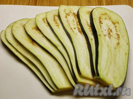 Баклажан хорошо моем, просушиваем от воды, отрезаем плодоножку и нарезаем на тонкие пластинки толщиной около 2 миллиметров (у меня получилось 9 пластинок, соответственно я в дальнейшем формировала 9 рулетиков).