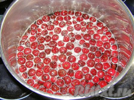 Ставим кастрюлю на медленный огонь и нагреваем, прикрыв крышкой, пока сахар не растворится. После этого огонь немного увеличиваем и доводим сироп с вишней до кипения, не накрывая крышкой. Затем варим 5 минут на минимальном огне, периодически удаляем образующуюся пену. Убираем кастрюлю с огня и оставляем вишню в сахарном сиропе полностью остыть.