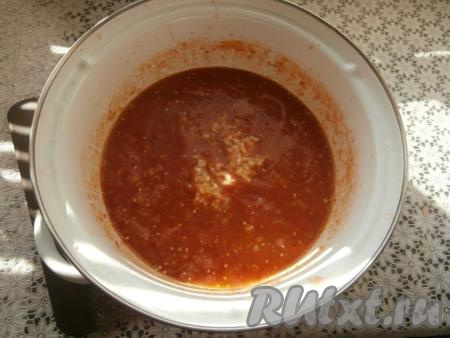 Через 30 минут добавить измельчённый чеснок, сушёный базилик, хмели-сунели, кориандр, влить уксус, перемешать. Варить аджику с баклажанами и яблоками ещё 15 минут.