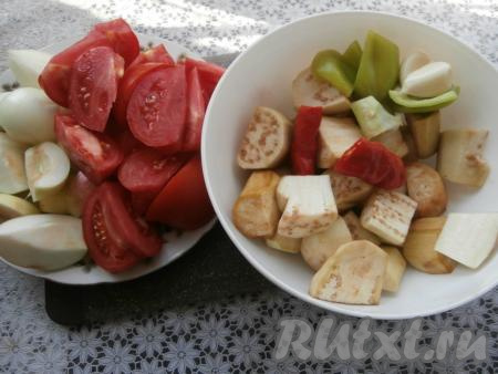 Баклажаны очистить от кожицы. Из яблок, болгарского и горького перцев удалить семена, промыть. Лук очистить. Вымыть помидоры. Баклажаны, перцы, яблоки, помидоры и лук нарезать достаточно крупно.