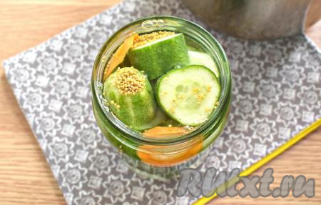 Для приготовления маринада наливаем в ковшик 300 миллилитров воды, ставим на огонь, всыпаем соль и сахар, перемешиваем, а после закипания на умеренном огне провариваем минуты 2-3 (за это время и сахар, и соль должны полностью раствориться), убираем с огня, вливаем уксус, очень хорошо перемешиваем. Горячий маринад сразу вливаем в банку с огурчиками и морковкой.