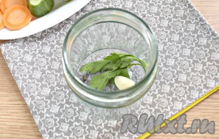 На дно простерилизованной банки кладём очищенный зубчик чеснока, промытые веточки петрушки, добавляем чёрный перец.&nbsp;&nbsp;