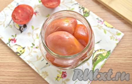 Тщательно промываем помидоры. Нарезаем их на половинки, которые плотно выкладываем в банки срезом вниз.