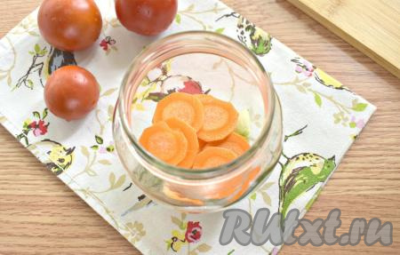 Очищаем морковку, нарезаем на тонкие кружочки, равномерно распределяем по банкам.