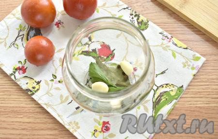 Банки для салата заранее простерилизуйте, а крышки к ним прокипятите в течение трёх минут. Я раскладывала заготовку по двум пол-литровым банкам. На дно каждой банки кладём 1 промытую веточку петрушки, 1 лавровый лист, 2 очищенных зубчика чеснока, 3 горошинки душистого и 3 горошинки чёрного перцев.