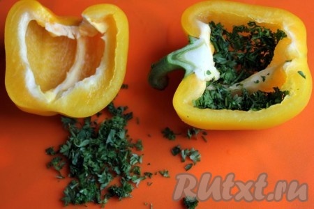 Перцы разрежьте пополам и очистите от семян. Проложите перцы внутри мелко рубленной петрушкой.