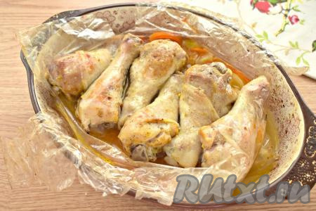Форму с рукавом ставим в разогретую до 200 градусов духовку, запекаем&nbsp;куриные ножки с овощами 45-50 минут. Затем достаём форму из духовки. Аккуратно, чтобы не обжечься, разрезаем рукав. Возвращаем форму с курицей и овощами в духовку ещё на 10 минут.