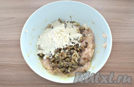 Затем в куриный фарш кладём остывшие обжаренные шампиньоны с луком, всыпаем 2 столовые ложки муки, перемешиваем.