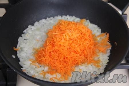 Натереть на мелкой тёрке морковку, выложить её к обжаренному луку, перемешать. Обжаривать овощи, иногда помешивая, 4-5 минут (морковь должна стать достаточно мягкой).